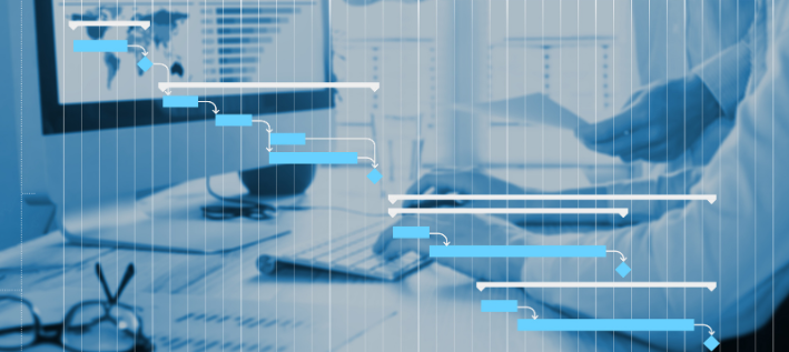 Person's hands at a computer desk with a stylized Gantt chart overlay in blue and white