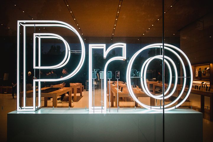 Looking inside a modern tech/device store with the neon word "Pro" in the window
